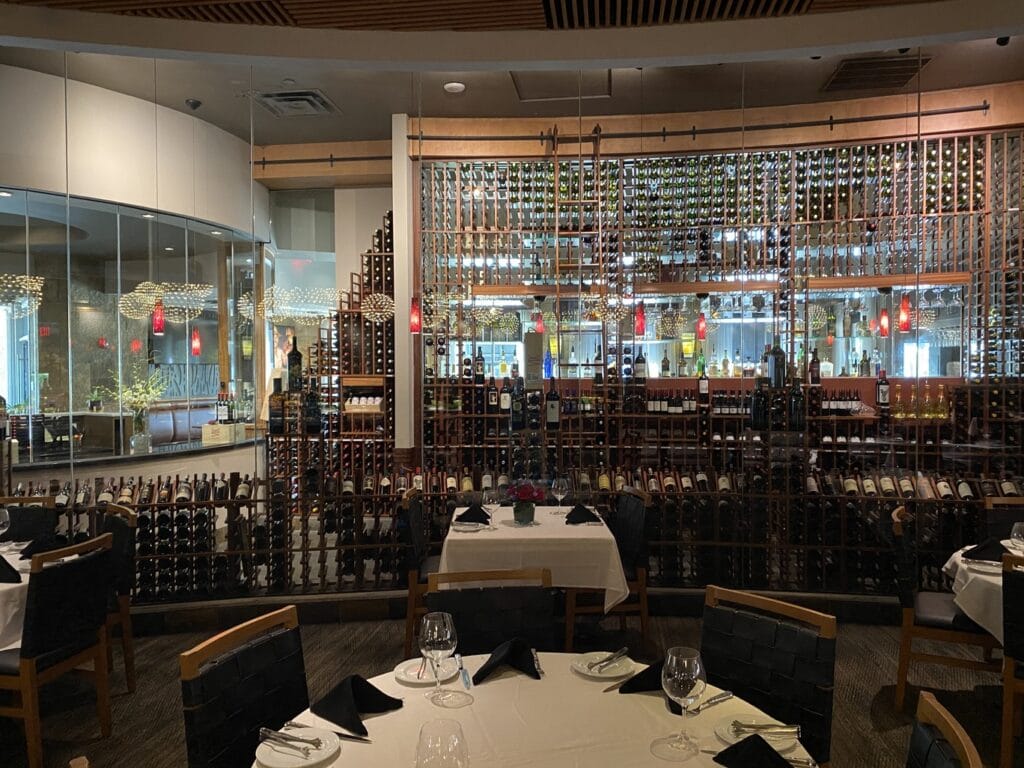 large wine storage area next to dining tables at Fogo de Chao
